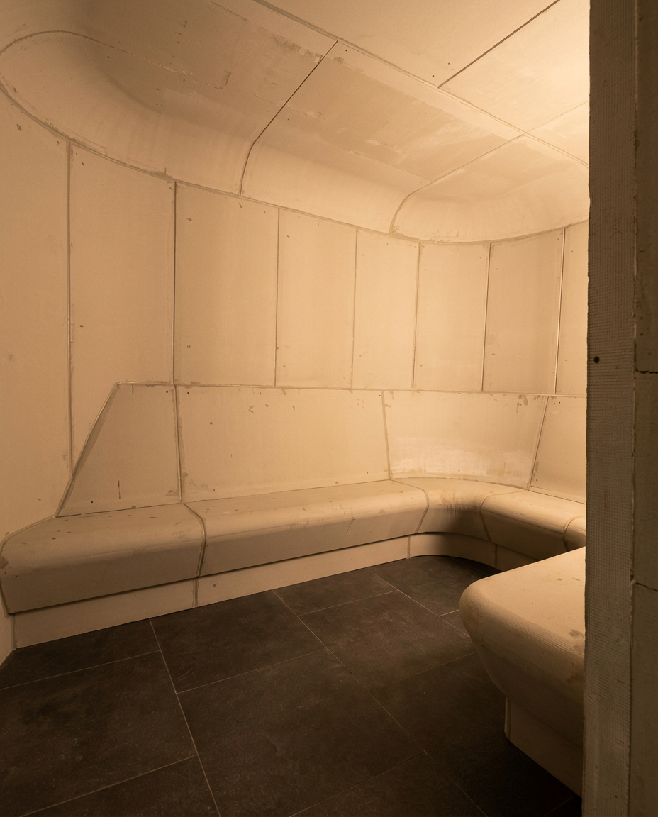 Aura unfinished steam room module with curved ceiling and integrated benches